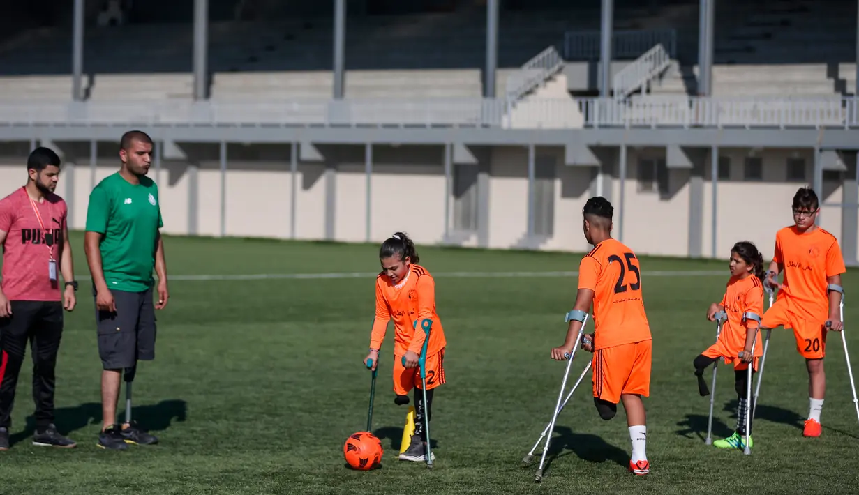 Anak-anak Palestina yang diamputasi berpartisipasi dalam sesi pelatihan sepak bola, yang diatur oleh Komite Palang Merah Internasional (ICRC) setelah pembatasan penyakit coronavirus (COVID-19) mereda, di Deir al-Balah di Jalur Gaza tengah (14/7/2020). (AFP/Mahmud Hams)