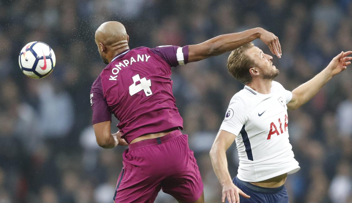 Pemain Manchester City, Vincent Kompany (kiri) menghalau bola dari jangkauan pemain Tottenham, Harry Kane pada lanjutan Premier League di Wembley Stadium, (14/4/2018). Manchester City menang 3-1. (AP/Frank Augstein)