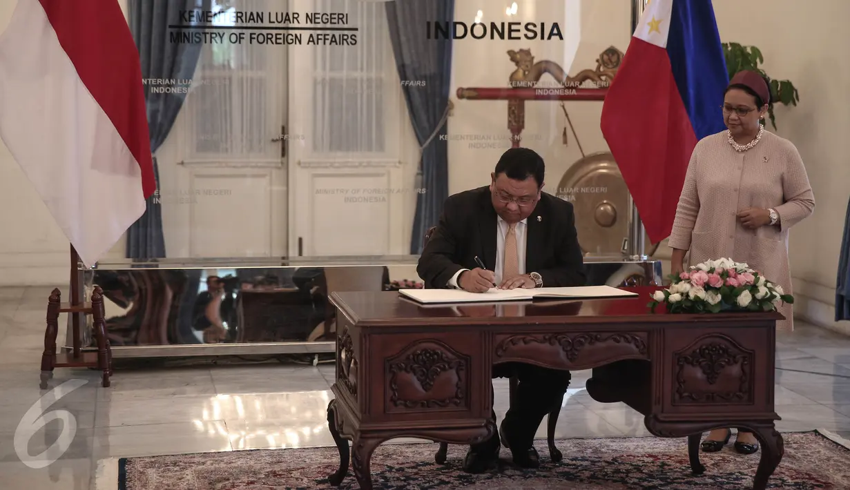 Menlu Filipina Jose Rene D. Almendras, didampingi Menlu RI Retno Marsudi, mengisi buku tamu saat kunjungan ke Kemenlu, Jakarta, Rabu (4/5). Pertemuan tertutup itu membahas pembentukan patroli gabungan untuk keselamatan maritim (Liputan6.com/Faizal Fanani)