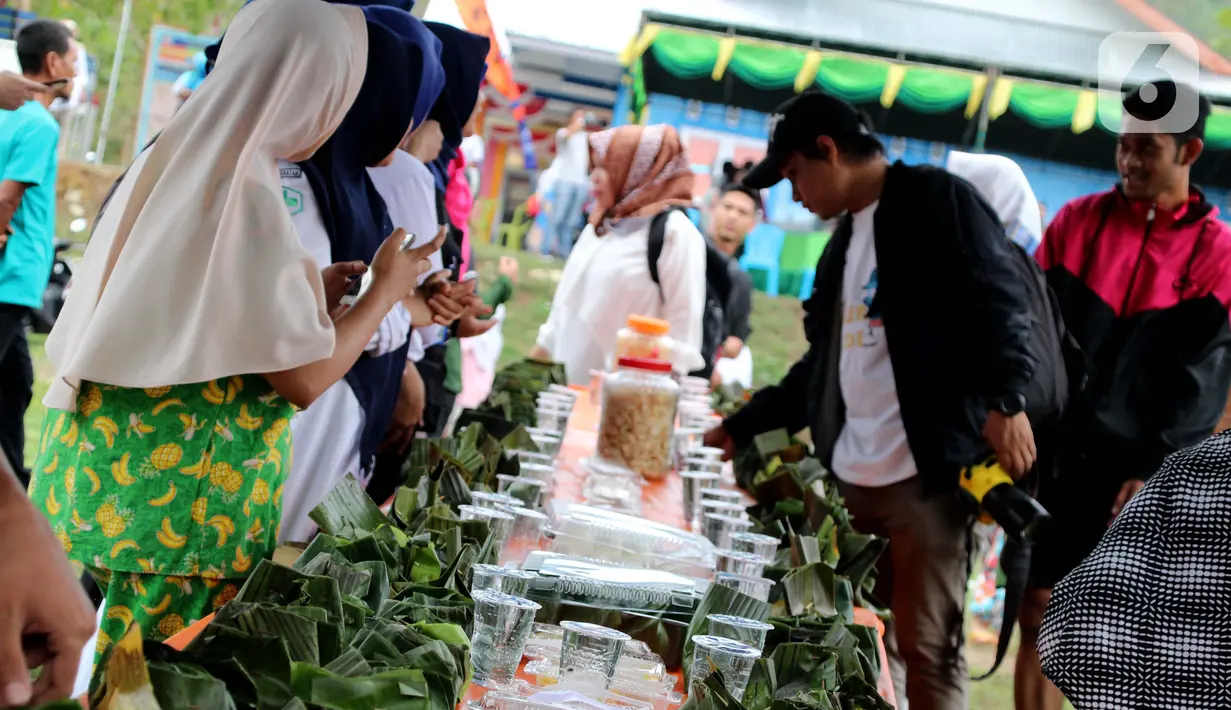 Warga mengambil bungkus nasi kuning selama Gebyar Safar 1441 H di Desa Pangi, Kecamatan Suwawa Timur, Kabupaten Bone Bolango (Bonebol), Rabu (23/10/2019). Sajian nasi bungkus ini memiliki makna tersendiri yang melekat di masyarakat Suwawa. (Liputan6.com/Arfandi Ibrahim)
