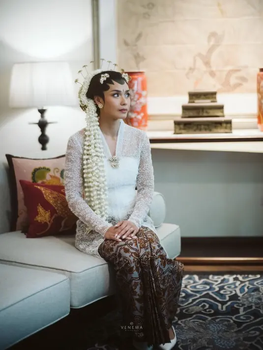 Adinia Wirasti tampak ayu bak ratu Jawa dengan kebaya pengantin yang lengkap. Kebaya manten panjang berwarna putih ini merupakan rancangan dari Kraton World. Penampilannya tak main-main dengan paduan kain batik sebagai bawahan dari Iwan Tirta. Foto: Instagram.