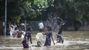 Anak-anak bermain di jalan yang tergenang air setelah hujan monsun di Gurgaon di pinggiran New Delhi (19/8/2020). Jumlah korban dari banjir tahunan di seluruh Asia Selatan naik menjadi hampir 1.300. (AFP/Xavier Galiana)