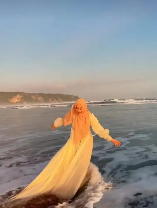 Ririe Fairus sempat berlibur di pantai. Kala itu dia terlihat anggun dengan dress putih yang dipadukan dengan kerudung coklat [instagram/ririe_fairus]