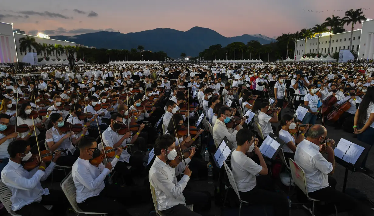 Musisi dari National System of Orchestras of Venezuela berusaha memecahkan rekor dunia bermain orkestra terbesar di dunia, di Akademi Militer Angkatan Darat Bolivarian di Caracas pada 13 November 2021. Sekitar 12 ribu musisi tersebut menyuguhkan pertunjukan selama 12 menit. (Federico PARRA/AFP)