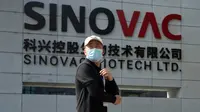 Seorang pekerja melewati logo di luar pabrik vaksin SinoVac di Beijing, Kamis (24/9/2020). Perusahaan farmasi China, Sinovac mengatakan vaksin virus corona yang dikembangkannya akan siap didistribusikan ke seluruh dunia, termasuk AS, pada awal 2021. (AP Photo/Ng Han Guan)