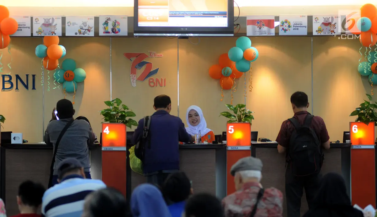 Teller melayani nasabah dan memberikan bunga mawar dan souvenir kepada nasabah di Kantor Cabang BNI Tebet, Jakarta (5/7). Kegiatan tersebut merupakan rangkaian HUT ke 72 BNI. (Merdeka.com/Arie Basuki)