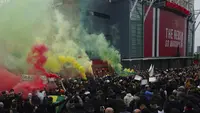 Fans Manchester United menyalakan suar saat menggelar protes sebelum laga Manchester United melawan Liverpool pada pertandingan Liga Inggris di Stadion Old Trafford, Manchester, Inggris, Kamis (13/5/2021). Fans menuntut pemilik Manchester United, keluarga Glazers, mundur. (AP Photo/Jon Super)