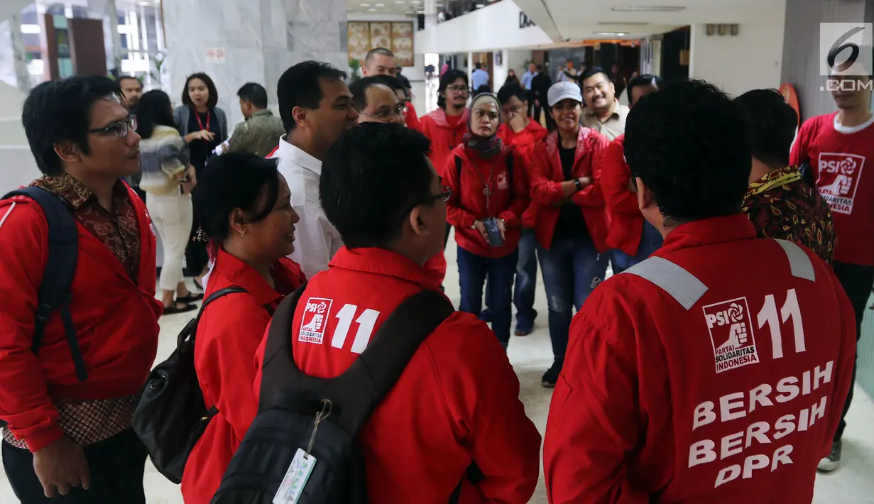 Calon legislatif dari Partai Solidaritas Indonesia (PSI) mendatangi gedung DPR RI di Senayan, Jakarta, Jumat (7/12). Kedatangan mereka untuk kampanye bersih-bersih DPR sambil mengenakan seragam merah ala cleaning service. (Liputan6.com/Johan Tallo)