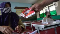 Wali murid menerima dua kartu perdana Tri dan Telkomsel beserta kuota gratis di SDN Serua Indah I dan II, Ciputat, Tangerang Selatan, Senin (15/9/2020). Program Kartu Perdana tersebut untuk mendukung kegiatan belajar secara online di masa pandemi covid-19. (merdeka.com/Dwi Narwoko)