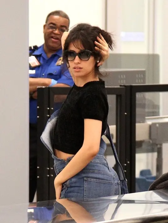 Usai melakukan pemeriksaan di airport Los Angeles, Camila melihat kamera paparazzi yang tengah membidiknya. (Splash News/Cosmopolitan)