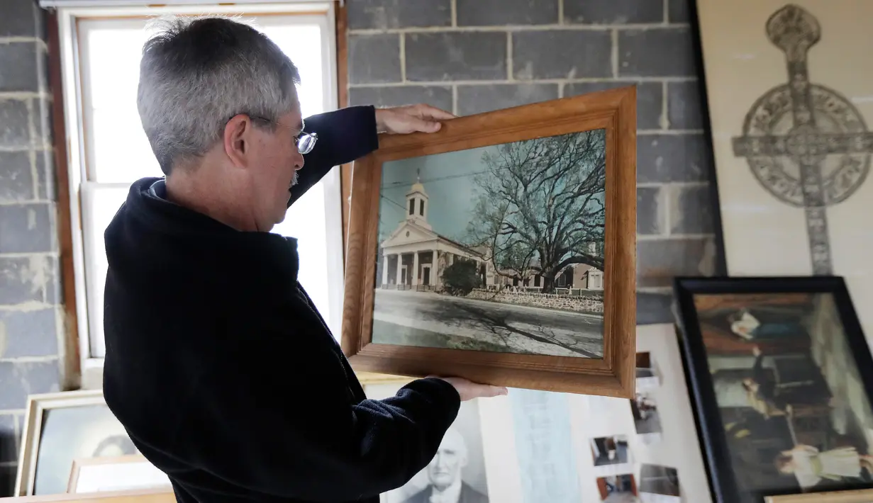 Seorang pria bernama Jon Klippel melihat foto yang tidak bertanggal, yang menggambarkan pohon Oak berusia 600 tahun pada waktu hidup di Basking Ridge Presbyterian Church di Bernards, New Jersey (21/4). (AP Photo/Julio Cortez)