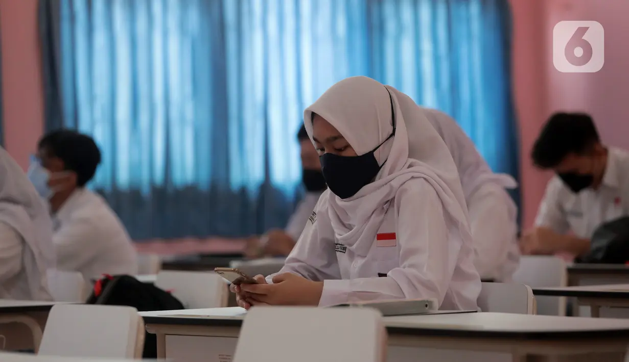 Siswa mengikuti uji coba pembelajaran tatap muka (PTM) terbatas di SMAN 1 Kota Tangerang, Banten, Senin (6/9/2021). Dinas Pendidikan Provinsi Banten uji coba PTM di SMA di Kota Tangerang secara terbatas dengan sistem bergiliran serta menerapkan protokol kesehatan ketat. (Liputan6.com/Angga Yuniar)