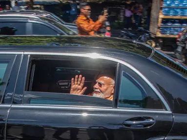 Perdana Menteri India Narendra Modi melambaikan tangan dari kendaraan saat tiba di Kompleks Candi Prambanan di Sleman, Yogyakarta, Rabu, 8 Juli 2026. (AFP/ Devi Rahman)