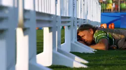 Seorang fotografer tengkurap di sebuah rumput saat mengambil momen terbaik balapan kuda wanita pada Olimpiade Rio 2016 di Deodoro Stadium, Rio de Janeiro, Brasil, (15/8). (REUTERS / Jeremy Lee)