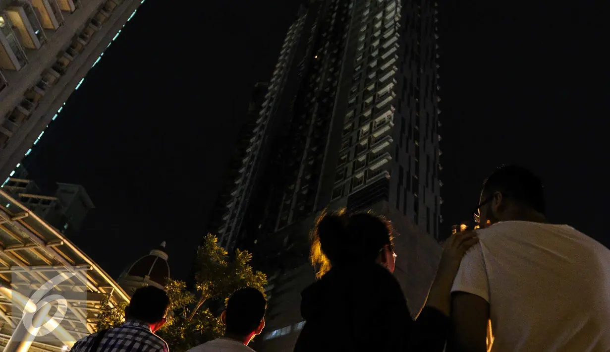 Warga melihat titik api yang masih tersisa di Gedung Neo Soho, Jakarta Barat, Rabu (9/11). Gedung Neo Soho sempat terbakar hebat hampir di setiap lantainya. (Liputan6.com/Faizal Fanani)