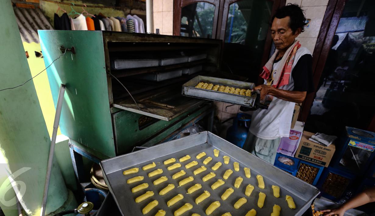 Pengrajin memasukan kue kering Lebaran ke dalam oven, di Kawasan Kwitang, Jakarta, Senin (29/6). Meskipun Lebaran masih beberapa pekan kedepan, produksi kue kering di sentra tersebut meningkat dua kali lipat. (Liputan6.com/Faizal Fanani)