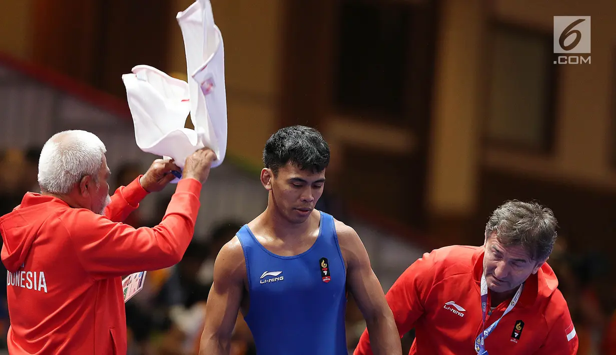 Ekspersi Pegulat putra Indonesia, Muhammad Aliansyah usai bertarung dengan Zhang Gaoquan dari China pada kelas putra 67 Kg di arena gulat JCC Senayan, Selasa (21/8). Aliansyah kalah atas lawanya dengan skor 0-7. (Liputan6.com/Fery Pradolo)