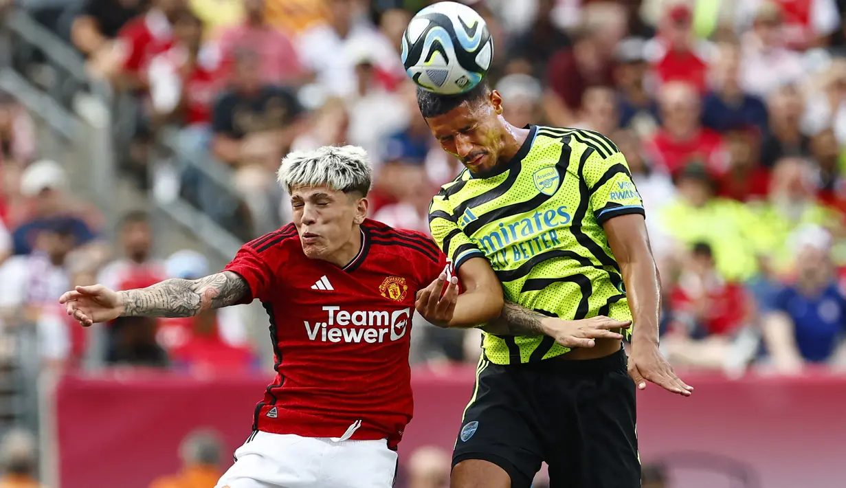 Bek Arsenal, William Saliba (kanan) memenangi duel udara dengan gelandang Manchester United, Alejandro Garnacho pada laga pramusim 2023/2024 di MetLife Stadium, New Jersey, USA, Minggu (23/7/2023) pagi WIB. (AFP/Getty Images/Rich Schultz)