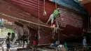 Para pekerja saat memperbaiki sebuah kapal di galangan kapal di tepi Sungai Yangon, yang terletak di pinggiran Yangon, Myanmar (30/7/2019). (AFP Phot/Sai Aung Main)