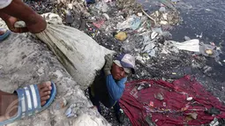 Pekerja berusaha mengangkat karung berisi kerang hasil tangkapan di Tempat Pelelangan Ikan Cilincing, Jakarta Utara, Rabu (8/2). (Fery Pradolo/Liputan6.com)