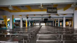 Deretan bangku kosong terlihat di aula sekolah yang tutup di Bangkok, pada Senin (4/1/2021). Pejabat kesehatan di Thailand pada Senin mencatat 745 kasus virus corona baru, rekor tertinggi harian di negara itu sejak pandemi COVID-19 melanda Negeri Gajah Putih pada Februari 2020. (Jack TAYLOR / AFP)