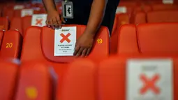 Seorang staf memasang penanda untuk mengingatkan pengunjung menjaga jarak sosial sebagai persiapan pembukaan kembali bioskop di Kuala Lumpur, Malaysia (26/6/2020). Pemerintah Malaysia mengizinkan bioskop dan teater untuk beroperasi kembali mulai 1 Juli mendatang. (Xinhua/Chong Voon Chung)