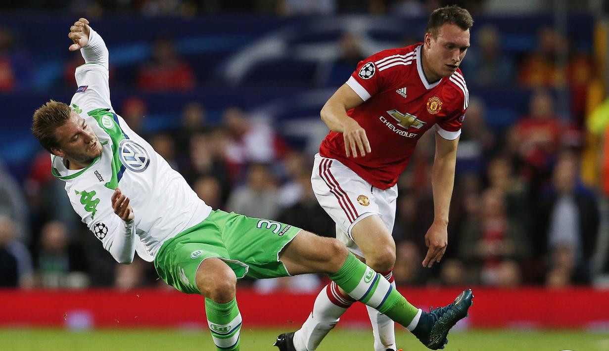 Pemain Manchester United, Phil Jones berebut bota dengan pemain Wolfsburg, Nicklas Bendtner pada laga Liga Champions di Stadion Old Trafford, Inggris, Kamis (1/10/2015). (Action Images via Reuters/Lee Smith)