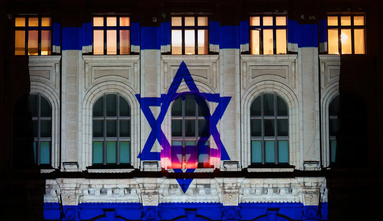 Bendera Israel menerangi Istana Parlemen sebagai bentuk solidaritas terhadap Israel di Bucharest, Rumania, Senin (9/10/2023). (AP Photo/Vadim Ghirda)