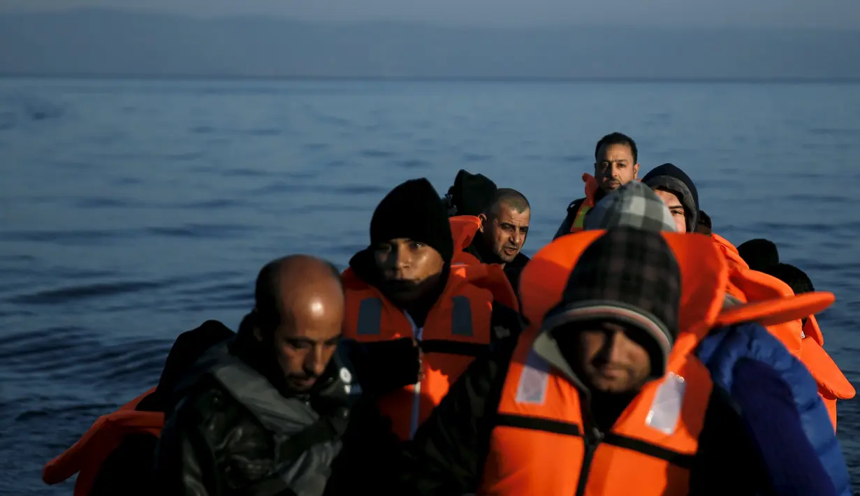 Pengungsi dan imigran saat berada di kapal di sampan kecil usai melintasi pulau Lesbos, Yunani, Senin (9/11). Sejak tahun 2015 lebih dari 590.000 imigran menyeberang ke Yunani akibat perang yang terjadi di Suriah. (REUTERS/Alkis Konstantinidis)