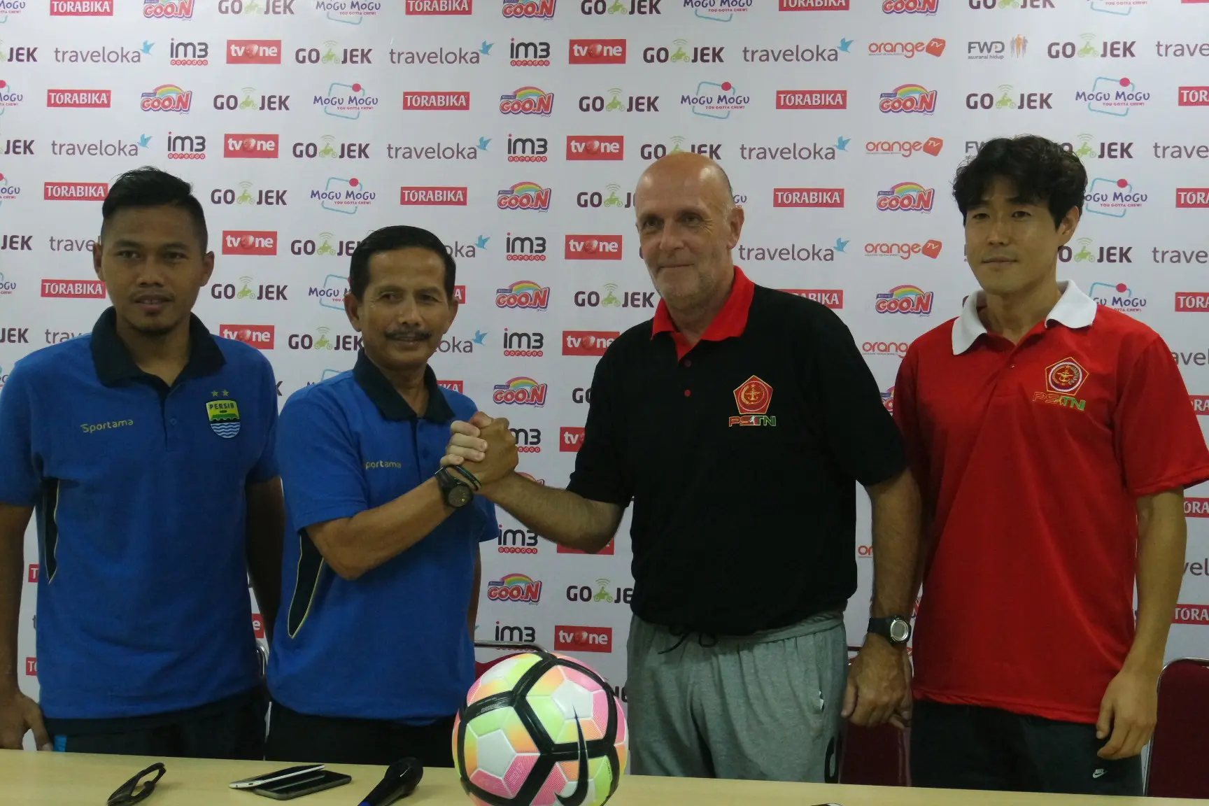 Pelatih Persib Bandung, Djadjang Nurdjaman, berjabat tangan dengan Pelatih PS TNI, Laurent Hatton, didampingi pemain dari masing-masing tim, Tony Sucipto dan Hong Soon-hak, jelang laga di Stadion Pakansari, Cibinong. (Bola.com/Benediktus Gerendo Pradigdo)
