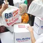 Warga menerima paket sembako Ramadan dari BUMN di di Jalan Rawa Bebek, Kecamatan Penjaringan, Jakarta Utara, Selasa (13/6). Setiap warga sudah dibekali kupon yang diberikan pihak BRI sehari sebelum pembagian. (Liputan6.com/Angga Yuniar)