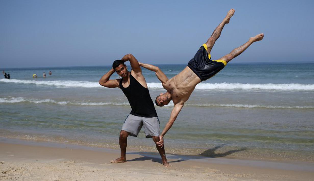 Anggota street workout Palestina, Bar Palestine, beraksi di pantai kota Gaza, Palestina. (7/8/2015). Street workout adalah latihan olahraga yang memanfaatkan fasilitas seadanya. (AFP Photo/Mohammed Abed)