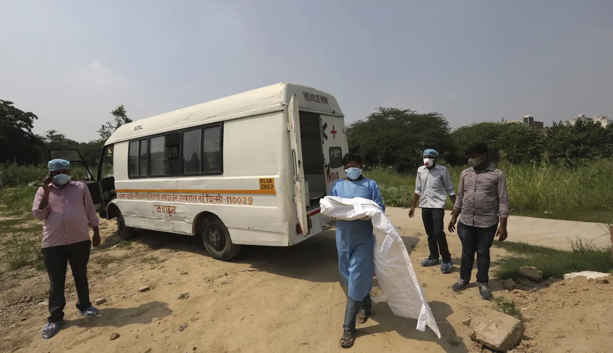 Seorang pria yang mengenakan pakaian pelindung diri menggendong tubuh putranya yang berusia tiga bulan yang meninggal karena COVID-19 di New Delhi, India, Rabu (16/9/2020). (AP Photo/Manish Swarup)