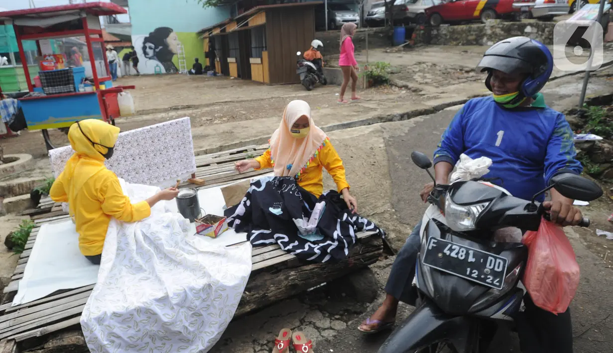 Warga menyelesaikan pembuatan batik tulis saat pelaksanaan kegiatan mural Raincity Strike #8 di Kampung Batik Cibuluh, Bogor, Minggu (22/11/2020). Kegiatan seni mural ini bertujuan diantaranya pengembangan kampung batik sebagai destinasi wisata dengan seni mural. (merdeka.com/Arie Basuki)