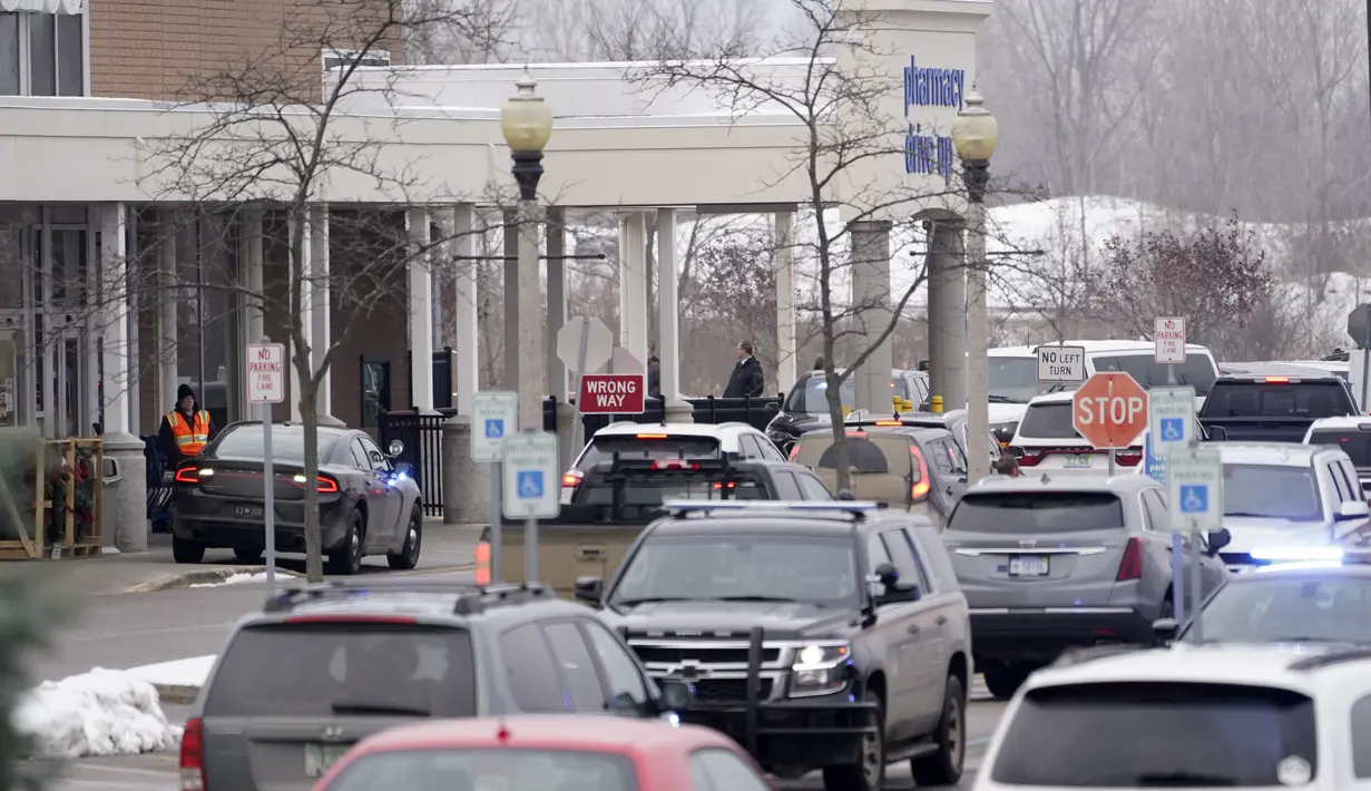 Polisi berada di tempat parkir toko Meijer tempat siswa Sekolah Menengah Oxford bertemu kembali dengan orang tua di Oxford, Michigan (30/11/2021). Tersangka ditangkap dalam waktu lima menit sejak panggilan 911 diterima kepolisian. (AP Photo/Paul Sancya)