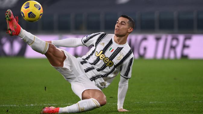 Penyerang Juventus, Cristiano Ronaldo menendang bola setelah kehilangan keseimbangan saat menghadapi Crotone dalam lanjutan Liga Italia di Allianz Stadium, Selasa dinihari (23/2/2021). Ronaldo menyumbang dua gol pada laga ini, sedangkan satu gol lagi disumbang Weston McKennie. (Marco BERTORELLO/AFP)