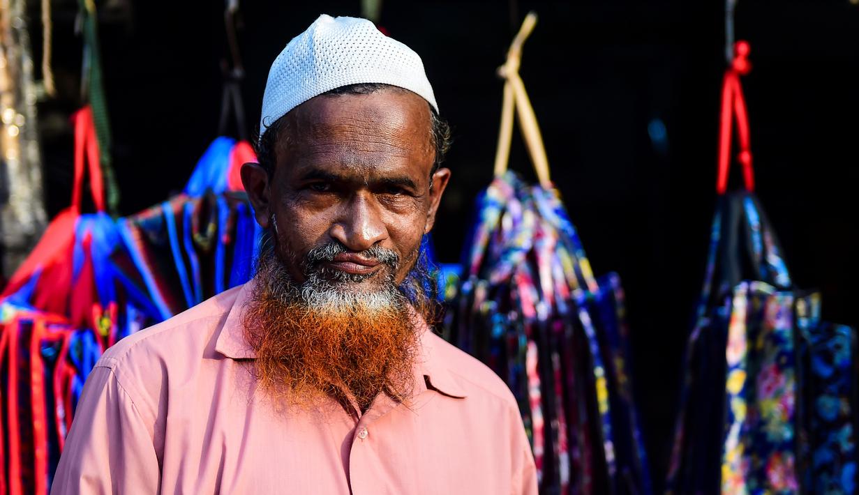 Dalam gambar yang diambil pada 24 Desember 2018, penjual sayur bernama Siddikur Rahman berpose dengan janggut oranye di Dhaka. Belakangan ini, pria-pria Muslim Bangladesh keranjingan berpenampilan dengan janggut warna-warna terang seperti merah hingga oranye. (MUNIR UZ ZAMAN / AFP)