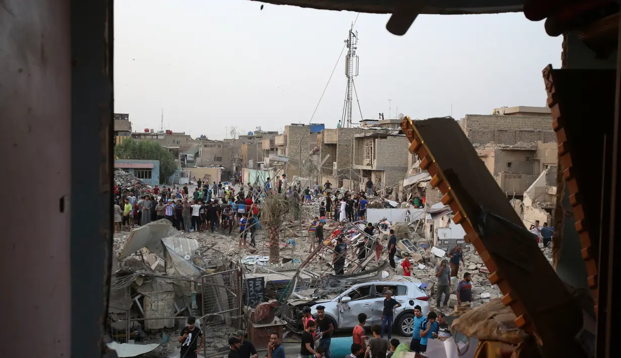 Orang-orang memeriksa tempat kejadian setelah ledakan di Kota Sadr di Baghdad, Irak, (7/6). Menurut pejabat setempat, sepasang ledakan bom menghancurkan sebuah masjid di distrik mayoritas Syiah di ibukota Irak. (AP Photo/Karim Kadim)