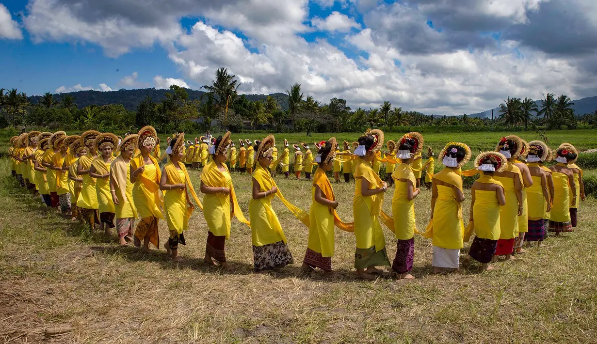 Para wanita yang mengenakan pakaian adat berbaris saat berjalan dalam ritual Hindu Bali bernama Usaba Sri di Karangasem, Bali, Senin, 10 Agustus 2026. (Foto AP/Firdia Lisnawati)