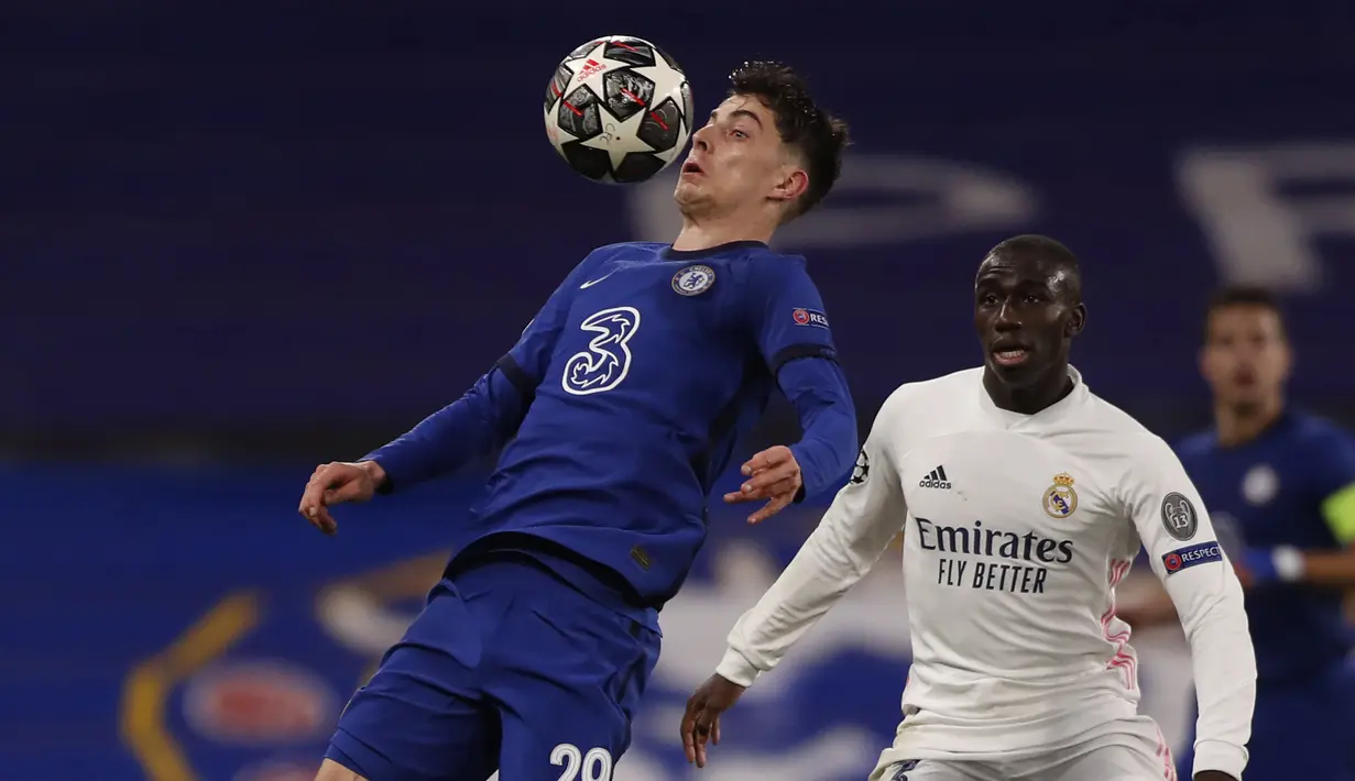 Gelandang Chelsea, Kai Havertz (kiri) mengontrol bola di depan bek Real madrid, Ferland Mendy dalam laga leg kedua semifinal Liga Champions 2020/2021 di Stamford Bridge, London, Rabu (5/5/2021). Chelsea menang 2-0 atas Real Madrid. (AP/Alastair Grant)
