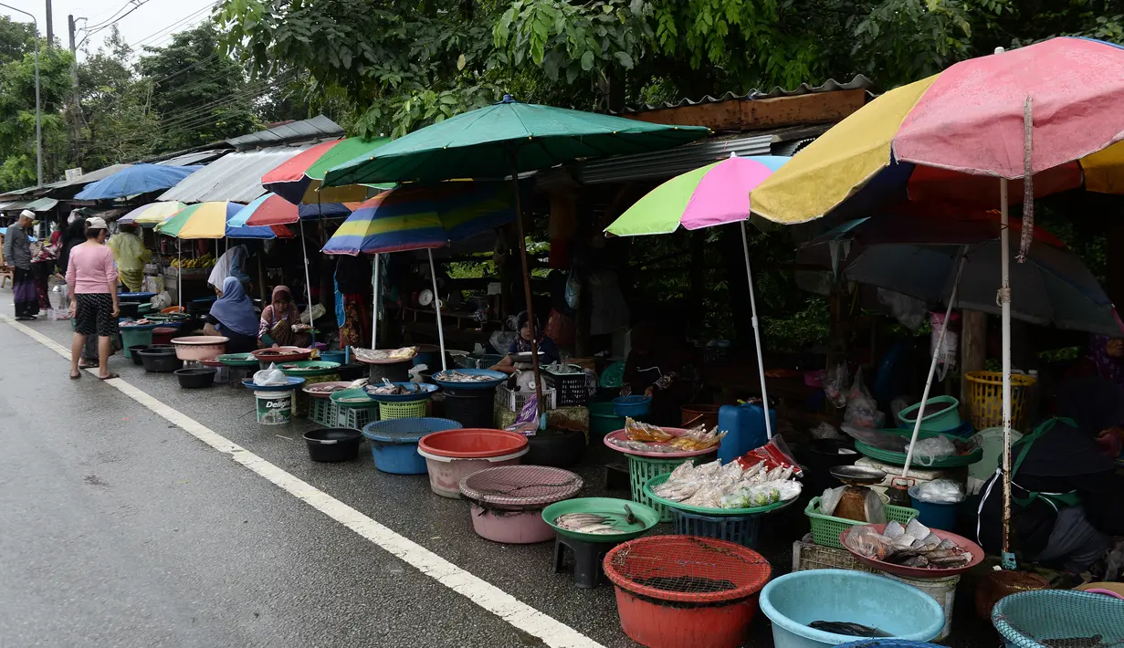 Sejumlah wanita muslim menjual ikan di pinggir jalan di Narathiwat, Thailand (19/12). Daerah ini sejak 4 Januari 2004 telah menjadi tempat terjadinya konflik antara pemerintah Thailand dan para separatis Muslim. (AFP Photo/Lillian Suwanrumpha)