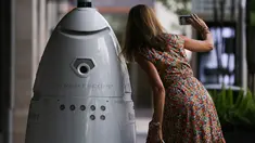 Seorang wanita berswafoto bersama robot keamanan baru yang bernama ROD2 di River Oaks District, Houston (18/8). Robot baru ini menjadi tambahan untuk tim pengaman dan patroli rutin di River Oaks District. (Michael Ciaglo / Houston Chronicle via AP)