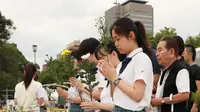 Para siswa berdoa untuk para korban bom atom menjelang peringatan di Hiroshima Peace Memorial Park, pusat kota Hiroshima, Selasa (5/8/2019). Pemerintah Jepang menggelar peringatan jatuhnya bom atom di Kota Hiroshoma 74 tahun lalu yang menandai berakhirnya Perang Dunia (PD) II. (JIJI PRESS / AFP)
