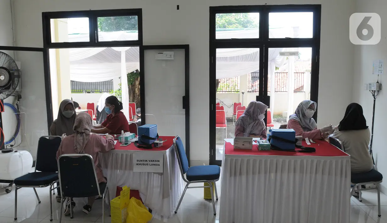 Paramedis memberikan vaksin booster saat pelaksanaan vaksinasi serentak Pemkot Depok di Kantor Kecamatan Cinere, Depok, Senin (18/4/20222). Gebyar vaksinasi booster secara massal ini bertujuan memberikan kemudahan bagi warga sebelum melakukan perjalanan mudik lebaran 2022. (merdeka.com/Arie Basuki)