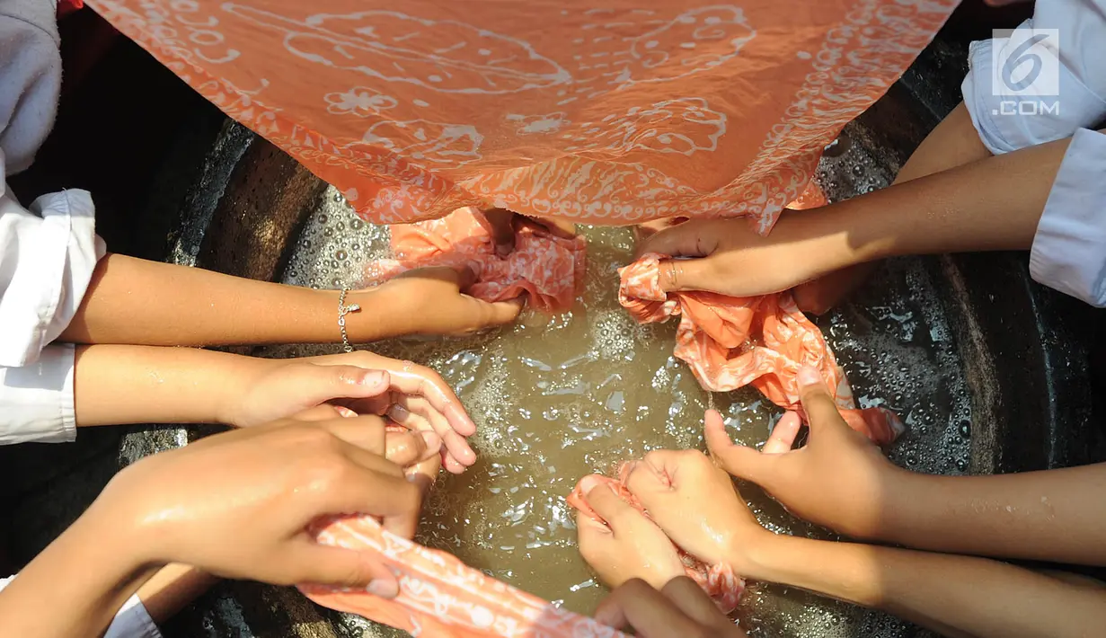 Murid kelas IV SDN Julang saat mencelupkan kain pada pewarna di Batik Tradisiku di Kota Bogor, Jawa Barat (2/10). Kegiatan selama 3 hari ini diselenggarakan secara gratis dalam rangka memperingati Hari batik Nasional 2 Oktober. (Merdeka.com/Arie Basuki)