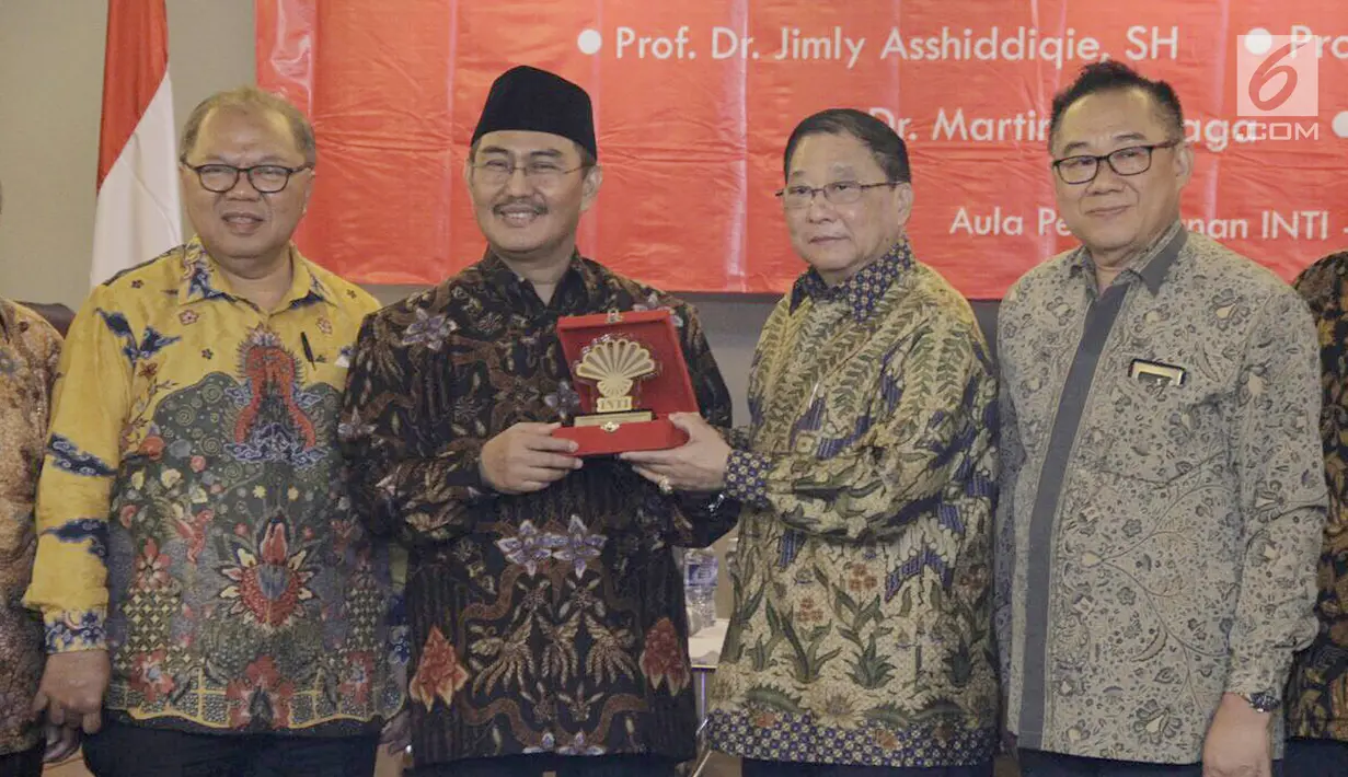 Tokoh Nasional Jimly Assidiqqi (kedua kiri) menerima cinderamata dari Ketua Umum Perhimpunan Indonesia Tionghoa (INTI), Teddy Soegianto (kedua kanan) dalam seminar Prospek Indonesia 2018 di Jakarta, Sabtu (16/12). (Liputan6.com/Iwan)