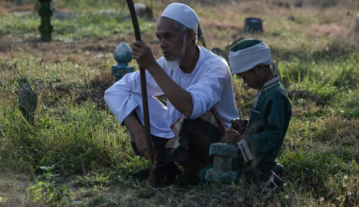 Muslim Thailand melakukan ziarah kubur pada perayaan Idul Adha di provinsi Narathiwat, Minggu (11/8/2019). Pada setiap Idul Adha atau menyambut hari besar Islam sebagian warga banyak mendatangi kuburan untuk mendoakan keluarganya. (Madaree TOHLALA/AFP)