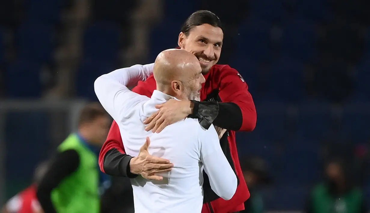Penyerang AC Milan, Zlatan Ibrahimovic memeluk pelatih Stefano Pioli usai mengalahkan Atalanta pada pertandingan Liga Serie A Italia di stadion Atleti Azzurri d'Italia di Bergamo, Senin (24/5/2021).  AC Milan mengakhiri Serie A 2020/2021 dengan finis sebagai runner up. (AFP/Marco Bertorello)