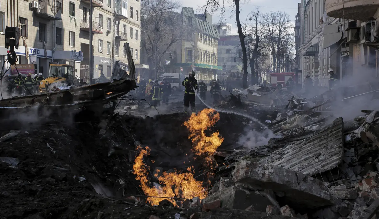 Petugas pemadam kebakaran memadamkan sebuah rumah apartemen setelah serangan roket Rusia di Kharkiv, kota terbesar kedua di Ukraina, Ukraina, Senin, 14 Maret 2022. (AP Photo/Pavel Dorogoy)