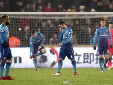 Pemain anyar Arsenal, Henrikh Mkhitaryan (tengah) terlihat kecewa saat timnya kalah dari Swansea City pada lanjutan Premier League di Liberty Stadium, Swansea, Wales, (30/1/2018). Arsenal kalah 1-3. (Nick Potts/PA via AP)